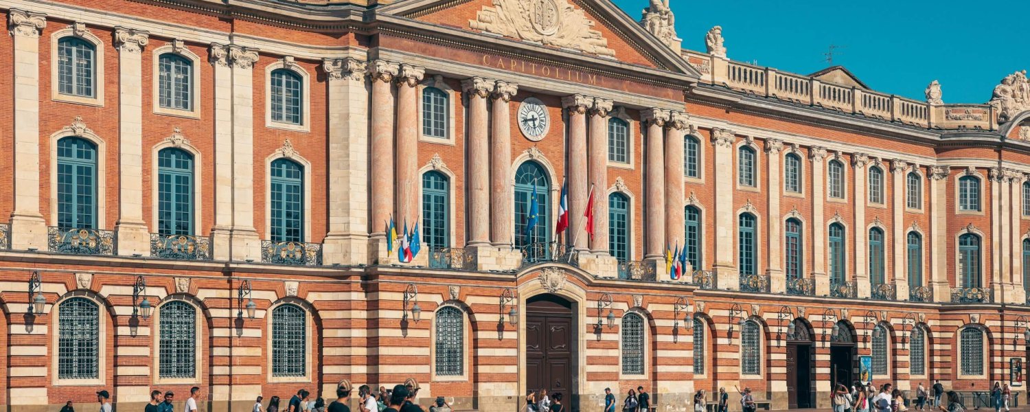 Fa&ccedil;ade du Capitole sur la place du Capitole &agrave; Toulouse, avec passants sur la grande esplanade